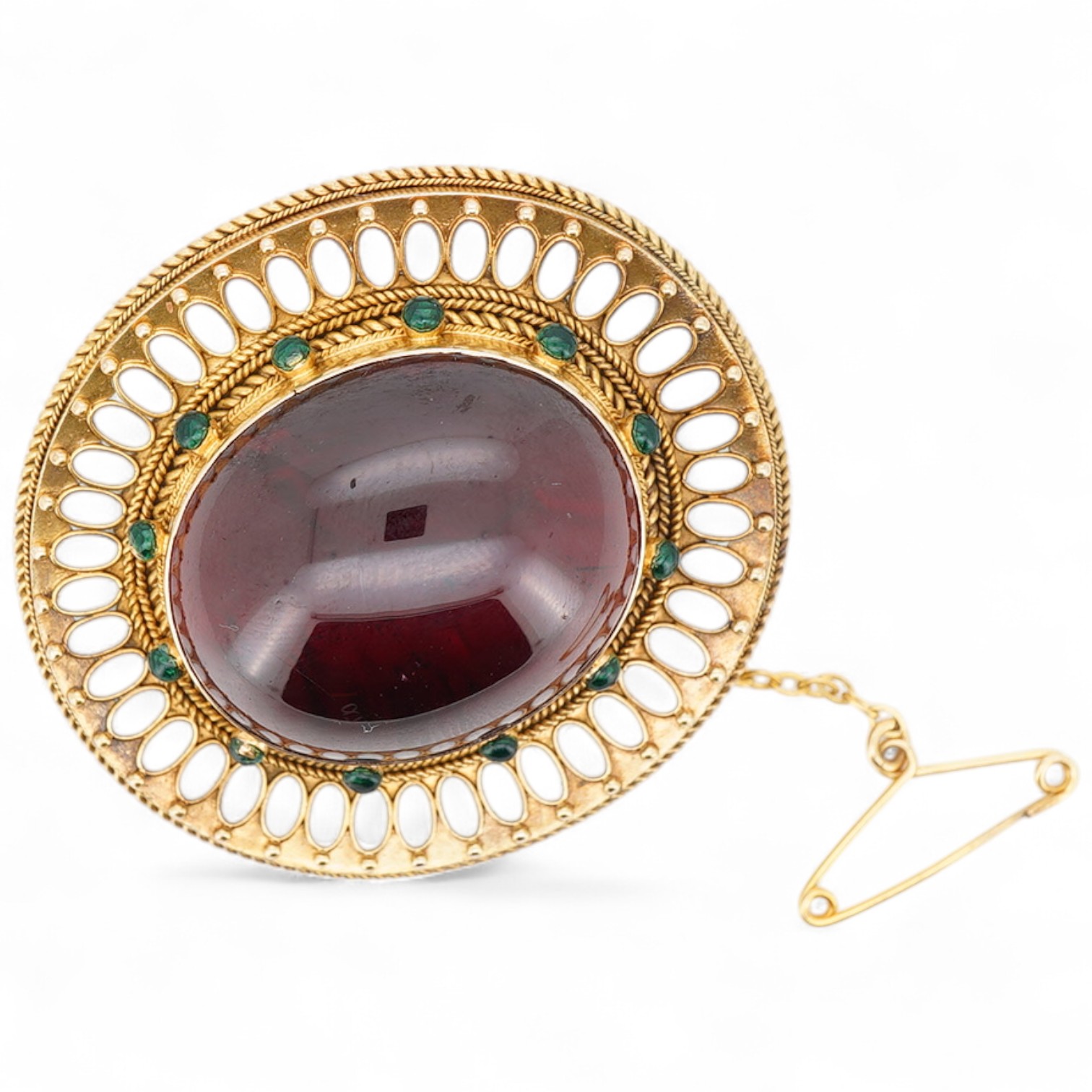 A garnet brooch, second half 19th century, designed in the Archaeological Revival style, centring on a large foiled cabochon garnet measuring approximately 25 x 21mm, within a border applied with rope twist decoration an
